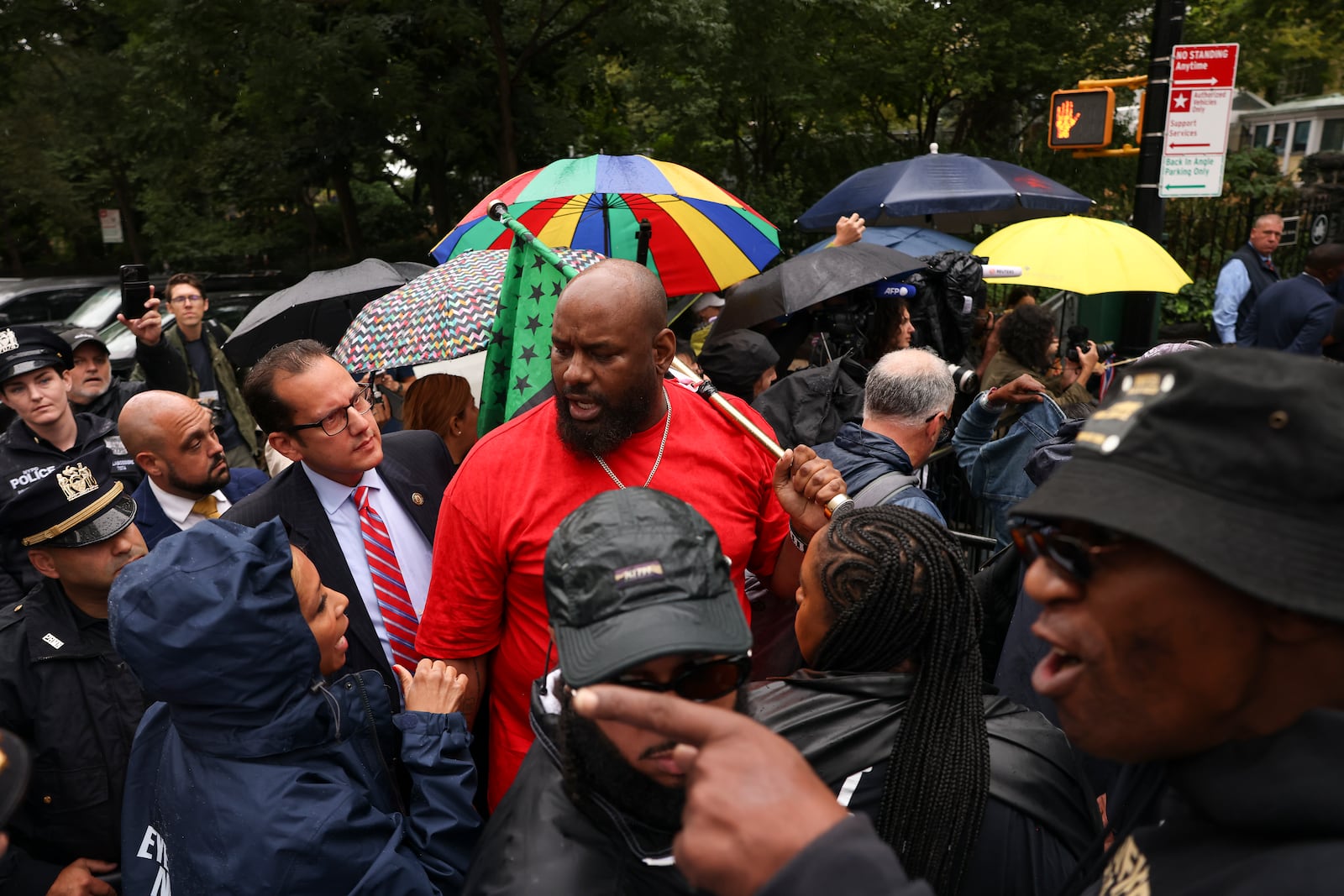 A protestor talks with law enforcement personnel and media while demonstrating against New York City Mayor Eric Adams during a news conference outside Gracie Mansion, Thursday, Sept. 26, 2024, in New York. (AP Photo/Yuki Iwamura)