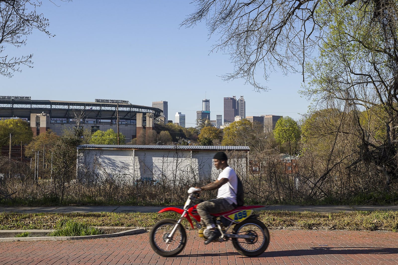 A man rides a dirt bike along brick-lined Atlanta Avenue in the Peoplestown community. 