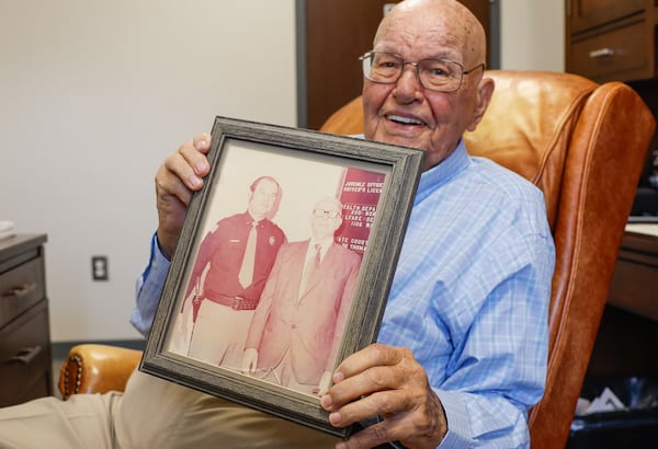 Houston County Sheriff Cullen Talton holds a photo he took with his father Cullen Talton Sr. on the day he became sheriff in 1973 in his office in Warner Robins, Ga. on Tuesday, April 16, 2024. Talton, 91, is the longest-serving sheriff in American history. (Natrice Miller/ AJC)