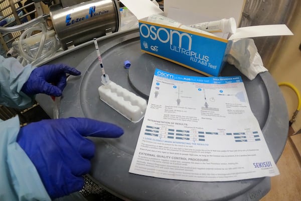 FILE - In this image provided by the U.S. Department of Agriculture, a researcher performs a rapid antigen test on milk from a dairy cow inoculated against bird flu in a containment building at the National Animal Disease Center research facility in Ames, Iowa, on Monday, July 29, 2024. (USDA Agricultural Research Service via AP, File)