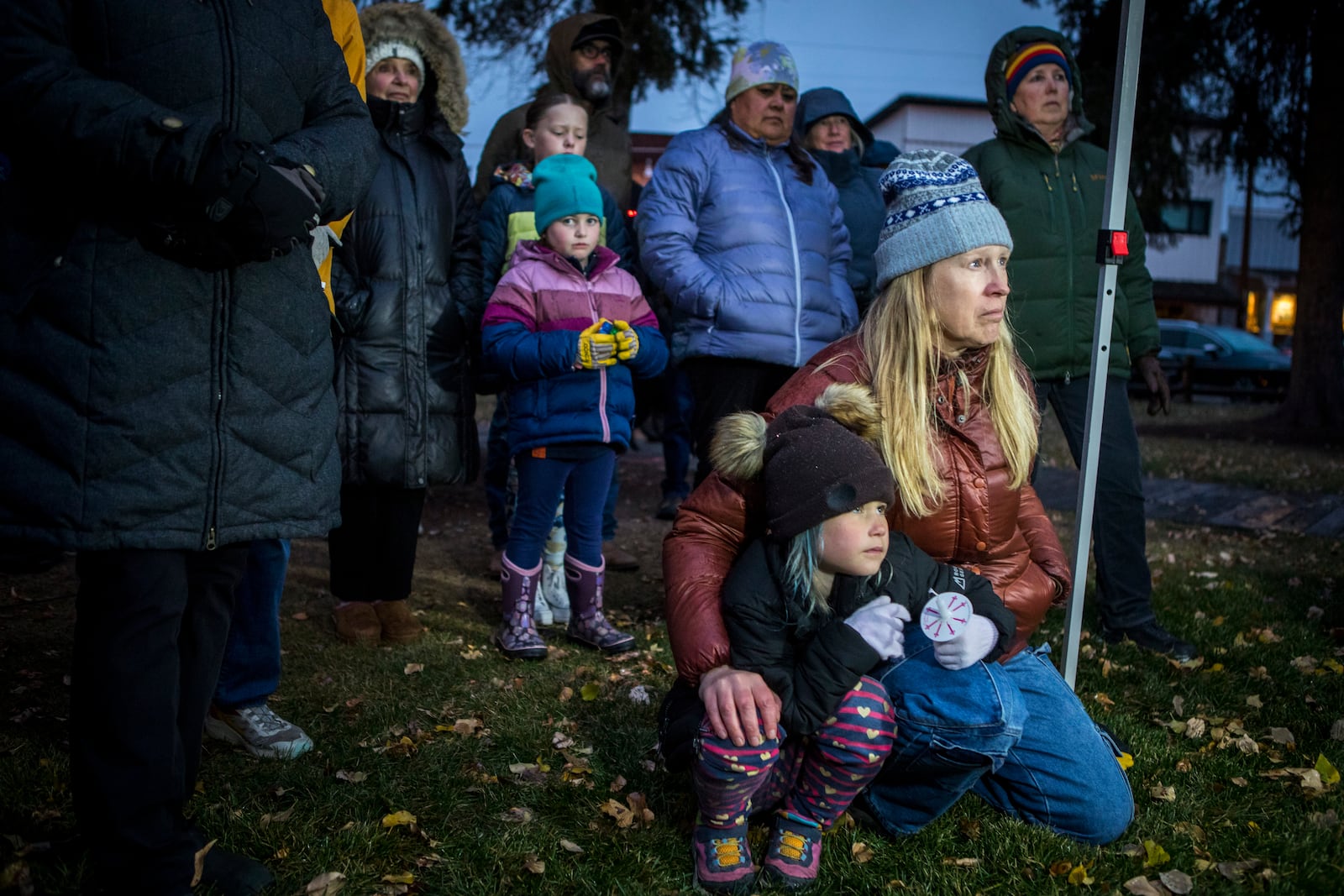 Rae Smith, 6, and her mother Leigh Reagan Smith listen to speakers at a candlelight vigil for grizzly bear No. 399 in Jackson, Wyo., Saturday, Nov. 2, 2024. (AP Photo/Amber Baesler)