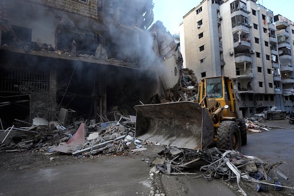 A bulldozer removes the rubble in front of a destroyed building that was hit Sunday night in an Israeli airstrike in Dahiyeh, in the southern suburb of Beirut, Lebanon, Monday, Nov. 25, 2024. (AP Photo/Hussein Malla)