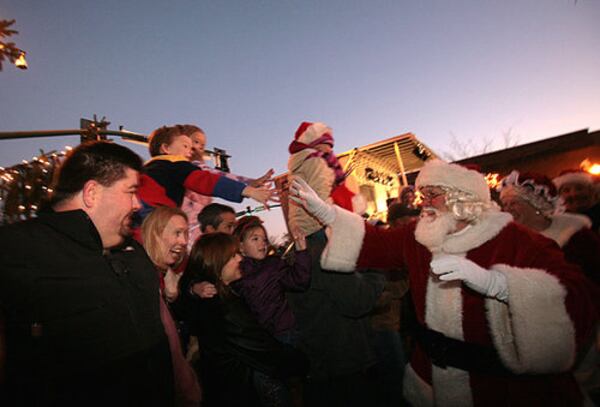 Santa Claus high fives children and parents as he arrives in historic downtown Alpharetta for the 31st Annual Christmas Tree Lighting Celebration.