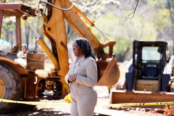 Trina Baynes stands in front of the site where her mother should have been buried more than two weeks ago. A broken backhoe sitting at her mother's gravesite at Carver Memorial Gardens had prevented her mother's proper burial.