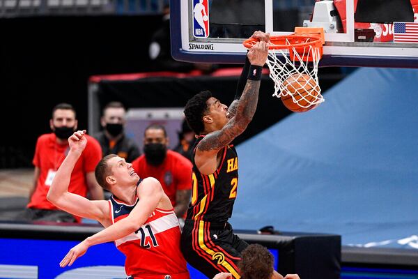 Atlanta Hawks forward John Collins, right, dunks past Washington Wizards center Moritz Wagner (21) during the second half of an NBA basketball game, Friday, Jan. 29, 2021, in Washington. (AP Photo/Nick Wass)