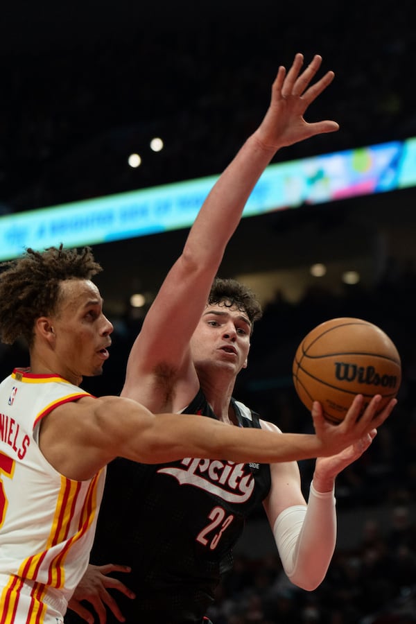 Atlanta Hawks guard Dyson Daniels, left, looks to shoot as Portland Trail Blazers center Donovan Clingan (23) defends during the first half of an NBA basketball game Sunday, Nov. 17, 2024, in Portland, Ore. (AP Photo/Jenny Kane)