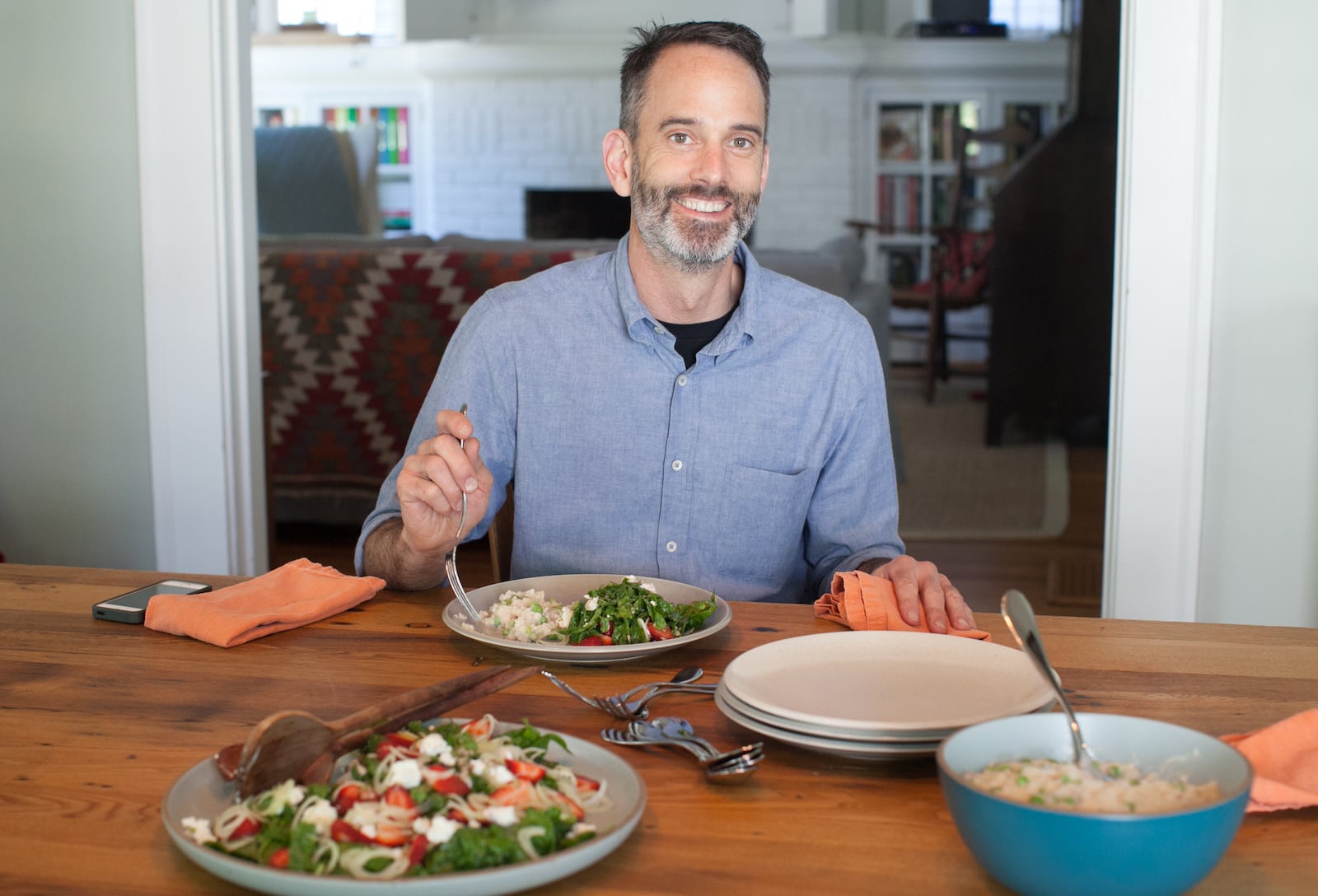 Steven Satterfield with two dishes from his first cookbook, "Root to Leaf: A Southern Chef Cooks Through the Seasons," including Spinach Salad with Strawberries and Rhubarb Vinaigrette and Southern risotto. (styling by chef Steven Satterfield) (Photography by Renee Brock/Special)