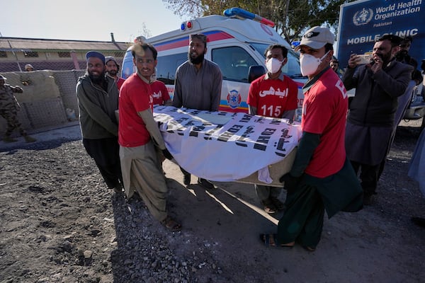 Rescue workers transport a coffin containing the body of a victim from a passenger train attacked by insurgents, upon arrival at a railway station in Much, Pakistan's southwestern Balochistan province, Thursday March 13, 2025. (AP Photo/Anjum Naveed)