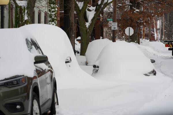 Cars are buried in snow on a side street in downtown Erie, Pa., Tuesday, Nov. 5, 2024. (AP Photo/Gene J. Puskar)