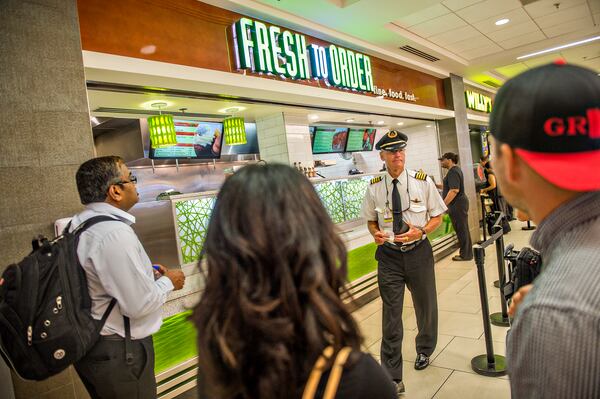 September 2, 2015 Atlanta - Capt. Dave Oeser (center) waits for his lunch after placing an order at Fresh to Order inside the Hartsfield Jackson Atlanta International Airport on Wednesday, September 2, 2015. Restaurants inside the airport have challenges including limited space, tethered knives, mandatory knife inventory inspections and electric grills. JONATHAN PHILLIPS / SPECIAL