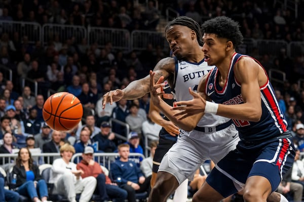 Butler forward Jahmyl Telfort reaches for a ball with St. John's guard RJ Luis Jr. during the first half of an NCAA college basketball game, Wednesday, Feb. 26, 2025, in Indianapolis, Ind. (AP Photo/Marc Lebryk)