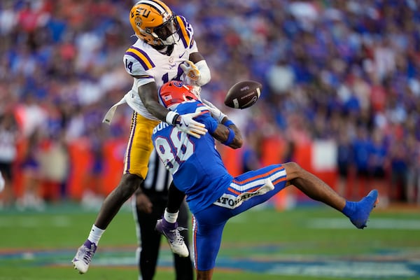 LSU cornerback Zy Alexander (14) breaks up a pass intended for Florida wide receiver Marcus Burke (88) during the first half of an NCAA college football game, Saturday, Nov. 16, 2024, in Gainesville, Fla. (AP Photo/John Raoux)