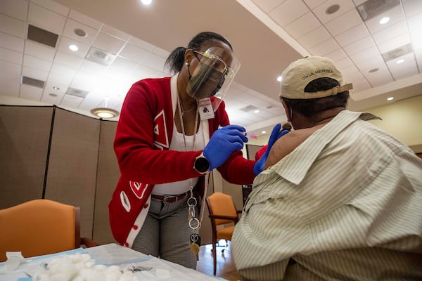 DeKalb County Board of Health medical worker Lisa Bridges administers a COVID-19 vaccination shot during a DeKalb County Board of Health and Delta Sigma Theta Sorority, Inc. COVID-19 vaccination event at the Lou Walker Senior Center in Stonecrest on Feb. 10. (Alyssa Pointer / Alyssa.Pointer@ajc.com)