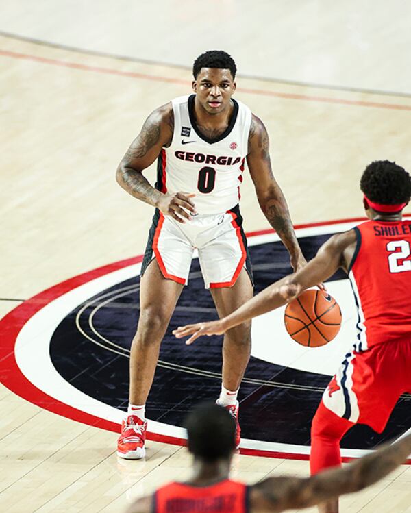 Georgia guard K.D. Johnson (0) drives against Ole Miss' Devontae Shuler Saturday, Jan. 30, 2021, at Stegeman Coliseum in Athens. The Bulldogs won 71-61. (Tony Walsh/UGA Sports)