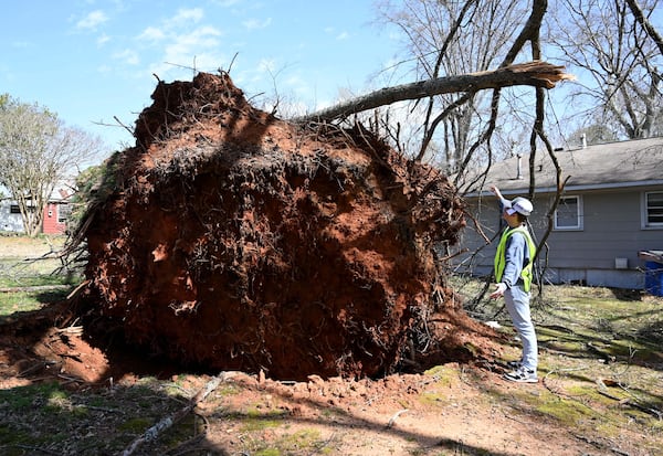 A worker measures the size of a fallen tree with a hand gauge after a storm passed through, Sunday, March 16, 2025, in Dallas. National Weather Service teams will be conducting a damage survey in the Paulding County/Dallas area, which sustained “pretty significant” damage from the storms, NWS Senior Meteorologist Dylan Lusk told The Atlanta Journal-Constitution on Sunday morning. (Hyosub Shin / AJC)