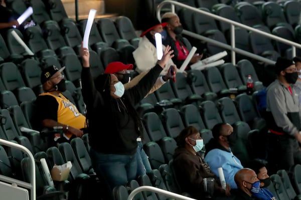 NBA fans wave glow sticks during the 3-Point Contest during NBA All-Star night Sunday, March 7, 2021, at State Farm Arena in Atlanta. (Curtis Compton/ccompton@ajc.com)