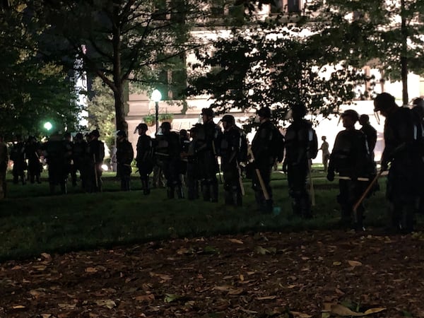 Law enforcement officers keep an eye on  on a group of protesters late Saturday night at the Capitol. (Photo: Christian Boone / AJC)