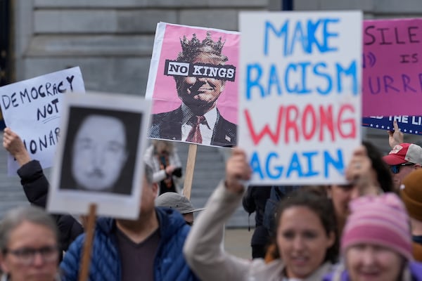 People hold up signs to protest the Trump administration Tuesday, March 4, 2025, in San Francisco. (AP Photo/Godofredo A. Vásquez)