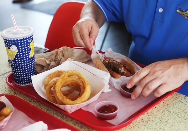 A customer prepares to eat his meal of a chili dog and onion rings with ketchup during the 70th anniversary celebration for Zesto at the Buckhead location. Zesto marked its 70th anniversary with 70 cent chili dogs for its customers, who packed the restaurant the morning of the all-day celebration. CHRISTINA MATACOTTA / CHRISTINA.MATACOTTA@AJC.COM