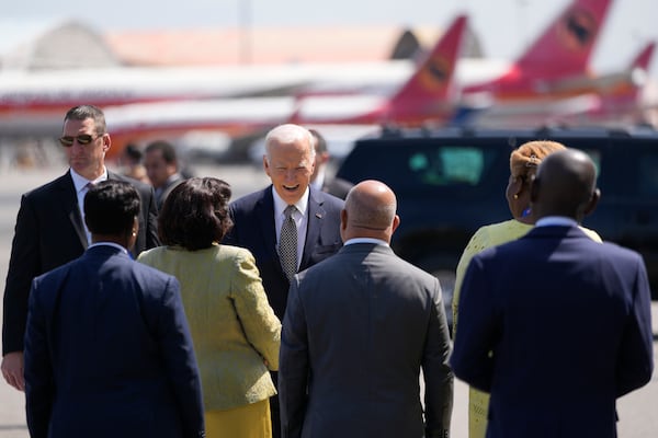 President Joe Biden talks to officials before boarding Air Force One today in Luanda, Angola.