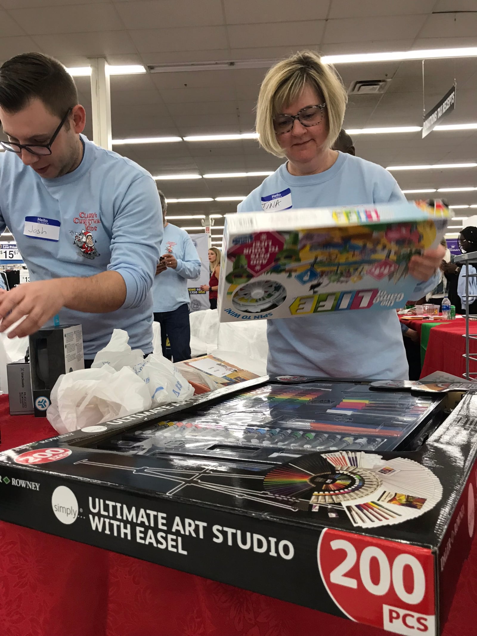 Volunteers Josh Hobbs and Tina Marshall help out with Clark's Kids on Thursday, November 29, 2018 at the Dunwoody Wal-Mart. CREDIT: Rodney Ho/rho@ajc.com