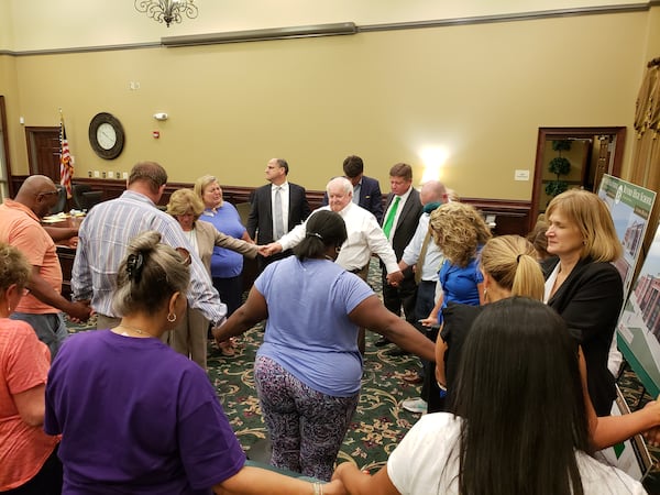 Phillip Beard and members of the school board pray with community members at an emotionally-charged meeting where the racial recordings involving former superintendent Geye Hamby were discussed. MATT KEMPNER/Atlanta Journal-Constitution