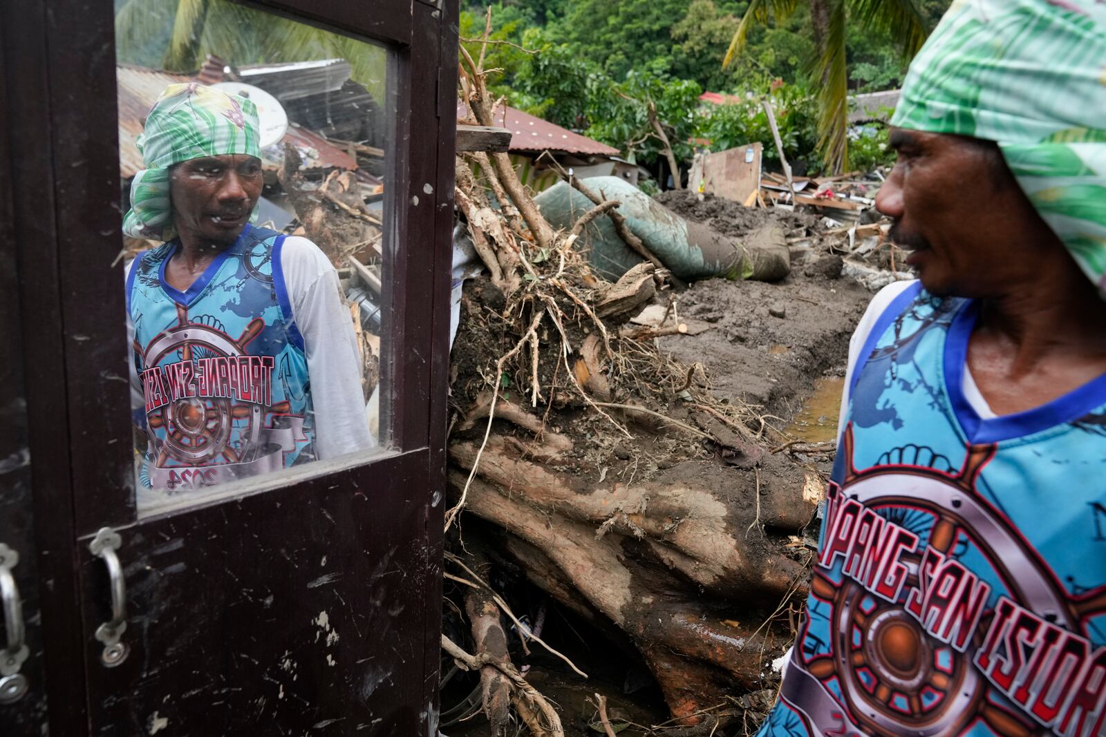 Marcelino Aringo speaks near his damaged house after a landslide triggered by Tropical Storm Trami struck homes, leaving several villagers dead in Talisay, Batangas province, Philippines on Saturday, Oct. 26, 2024. (AP Photo/Aaron Favila)