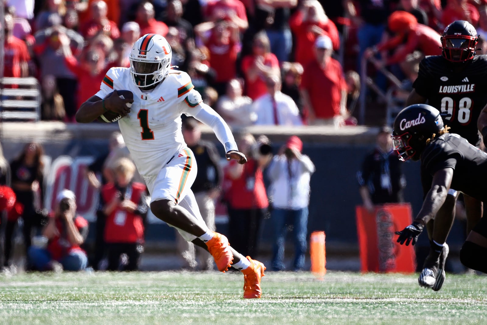 Miami quarterback Cam Ward (1) runs from the pursuit of the Louisville defense during the second half of an NCAA college football game in Louisville, Ky., Saturday, Oct. 19, 2024. Miami won 52-45. (AP Photo/Timothy D. Easley)