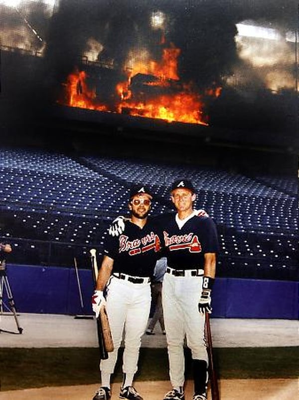 Mark Lemke (left) and Jeff Blauser posed for a quick photo as the fire burned above them. 