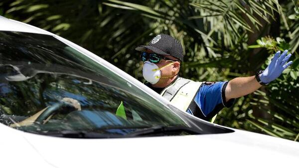 Police check cars and pedestrians at a checkpoint at the entrance to the Village of Key Biscayne, Fla., Monday, March 23, 2020. (AP Photo/Wilfredo Lee)