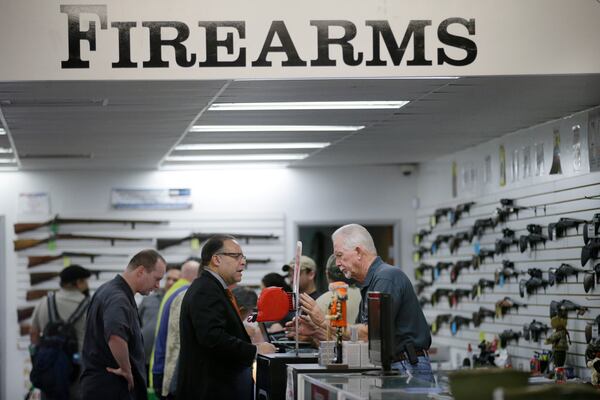 In this Dec. 9, 2015, photo, sales associate Mike Conway, right, shows Paul Angulo a pistol at Bullseye Sport gun shop in Riverside, Calif. The massacre at Sandy Hook elementary school in which a mentally disturbed young man killed 26 children and teachers galvanized calls across the nation for tighter gun controls. But in the three years since, many states have moved in the opposite direction, embracing the National Rifle Associations response that more good guys with guns are whats needed to limit the carnage of mass shootings. (AP Photo/Jae C. Hong)