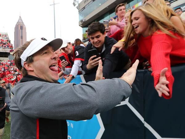 Georgia football head coach Kirby Smart high fives fans after beating Georgia Tech 38-7 in Atlanta. Will fans of UGA and other universities be less willing to buy season tickets if a juicy tax deduction is eliminated? Curtis Compton/ccompton@ajc.com