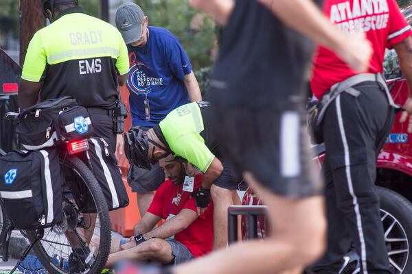 A runner is checked by Grady hospital EMS during the 49th running of the AJC Peachtree road race near Piedmont Park, Wednesday, July 4, 2018.  ALYSSA POINTER/ALYSSA.POINTER@AJC.COM