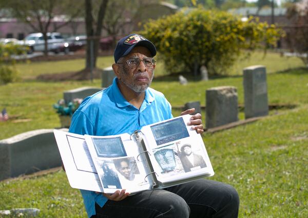 Charles Grogan holds a book of historic documents in 2016 that he's collected of his relatives and others at the Pleasant Hill Cemetery in Roswell. PHOTO / JASON GETZ