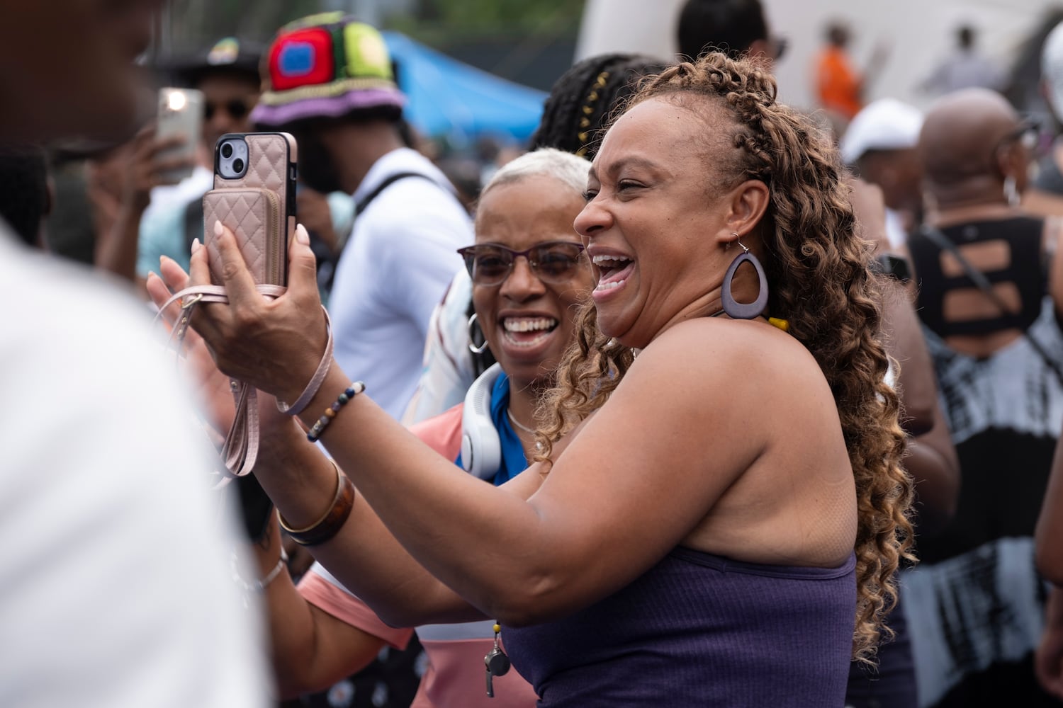 Faneshia Bolds, left, and Toya Clay video chat with a close friend in Illinois as they dance to the music at the 20th anniversary of the House In The Park music festival in Grant Park in Atlanta on Sunday, Sept. 1, 2024. (Ben Gray / Ben@BenGray.com)