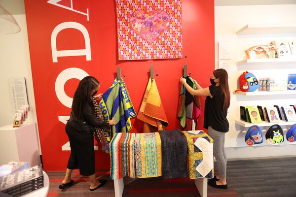 Tiffany Ricks, left, community engagement coordinator, and Miranda Hazelwood, visitor experience manager at Museum of Design Atlanta, organize the blankets that have been donated. The blankets will be on display to the public. Miguel Martinez/for The AJC