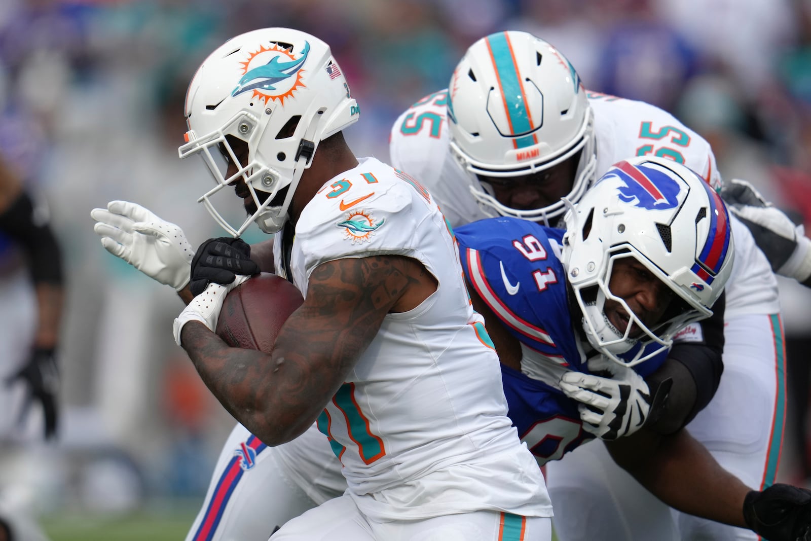 Miami Dolphins running back Raheem Mostert, left, runs as Buffalo Bills defensive tackle Ed Oliver (91) defends during the second half of an NFL football game Sunday, Nov. 3, 2024, in Orchard Park, N.Y. (AP Photo/Gene Puskar)