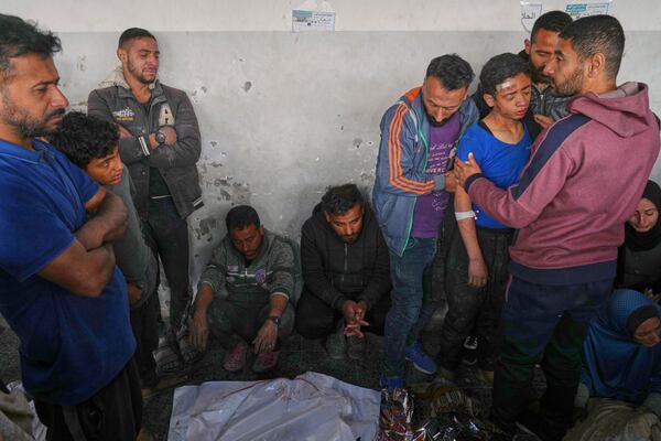 Mahmoud Al-Sayfi, 13, right with blue shirt, is comforted by relatives as he mourns both his parents killed during an Israeli army strike before their burial at the Baptist hospital in Gaza City, Monday, March 24, 2025.(AP Photo/Jehad Alshrafi)