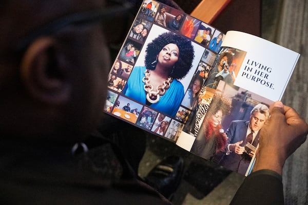 An attendee flips through the program at the memorial service for singer and actress Angie Stone, Friday, March 14, 2025, in Austell. Ga. (AP Photo/Olivia Bowdoin)