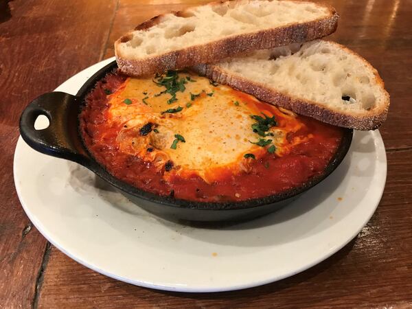 Shakshuka from Alon’s Bakery & Market includes rounds of Moroccan lamb sausage. LIGAYA FIGUERAS / LFIGUERAS@AJC.COM