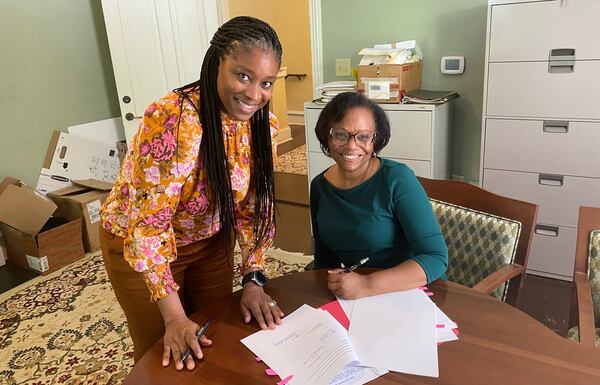 Shawanna Qawiy (left) and Mayor Beverly Burks (right) sign the contract that made Qawiy the city manager of Clarkston.