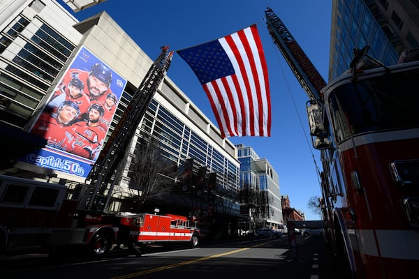 Una bandera estadounidense se vuela fuera de la Capital One Arena antes del evento Legacy on Ice, un tributo de patinaje artístico para apoyar a las familias y seres queridos afectados por el trágico incidente de la aviación del 29 de enero, domingo 2 de marzo de 2025, en Washington. (AP Photo/Nick Wass)