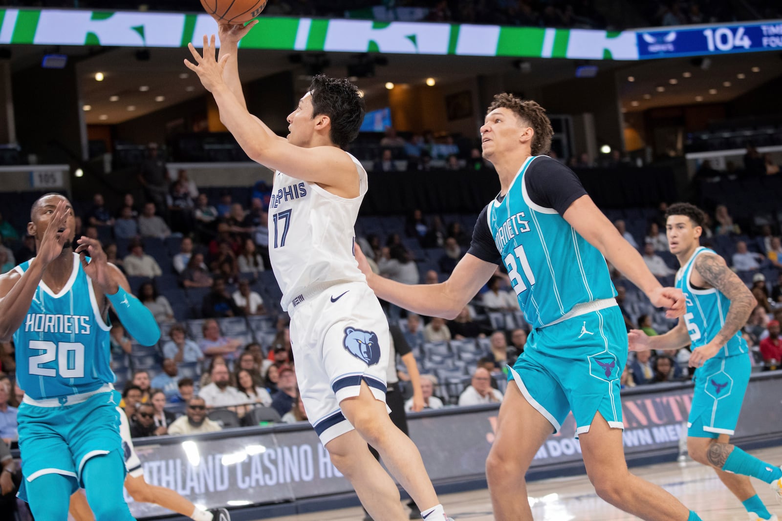 Memphis Grizzlies guard Yuki Kawamura (17), of Japan, shoots defended by Charlotte Hornets forward Harry Giles, forward Tidjane Salaun (31), of France, and guard K.J. Simpson (25) in the second half of a preseason NBA basketball game Thursday, Oct. 10, 2024, in Memphis, Tenn. (AP Photo/Nikki Boertman)