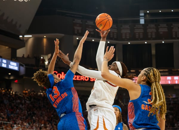 Texas forward Kyla Oldacre, center, shoots against Florida forward Alexia Gassett, right, and guard Laila Reynolds, left, during the second half an NCAA college basketball game, Sunday, March 2, 2025, in Austin, Texas. (AP Photo/Michael Thomas)