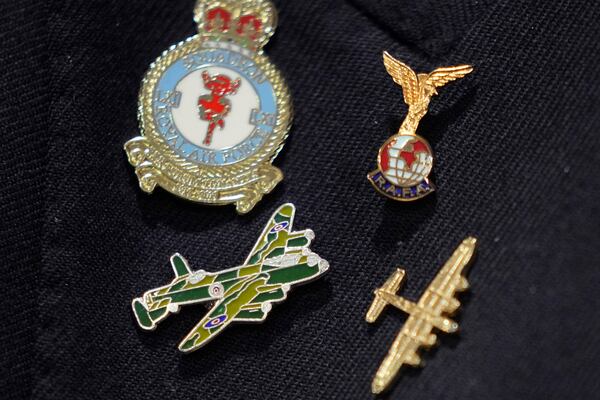 Michael Woods, 100-year-old World War II veteran wears a pin featuring a Lancaster Bomber during an interview in Dunstable, Bedfordshire, England, Tuesday, Nov. 5, 2024. (AP Photo/Kin Cheung)