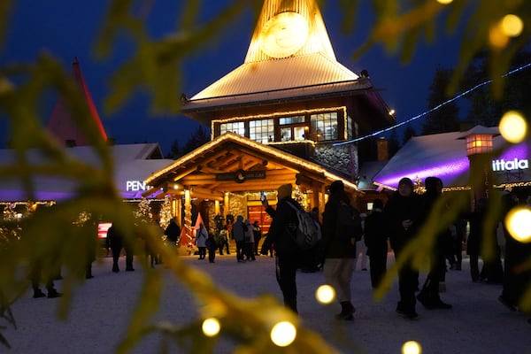 Tourists gather at Santa Claus Village, a winter-themed amusement park perched on the edge of the Arctic Circle, in Rovaniemi, Finland, Wednesday, Dec. 4, 2024. (AP Photo/James Brooks)