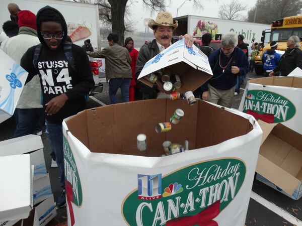 Ray Holmes, volunteering for the first time, moves cans into categories. CREDIT: Rodney Ho/rho@ajc.com