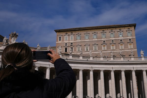 A woman takes a photograph of the window at the Vatican where Pope Francis would usually bestow his blessing, the Pontiff is currently recovering from a bilateral pneumonia at Rome's Agostino Gemelli Polyclinic, in Rome, Sunday, March 2, 2025. (AP Photo/Kirsty Wigglesworth)