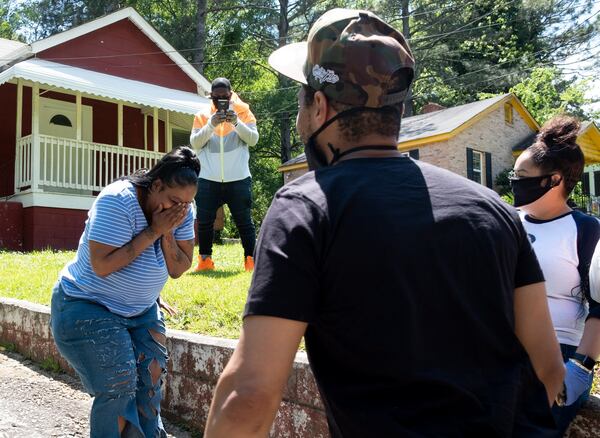 Niya Woods reacts as T.I. walks up her driveway to surprise her with hygiene supplies and $500 on May 6, 2020. Ben@BenGray.com for the Atlanta Journal Constitution