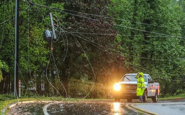 A fallen tree took down power lines on Shallowford Road near Jones Road in Roswell when a system of storms swept through metro Atlanta Friday morning. JOHN SPINK / JSPINK@AJC.COM